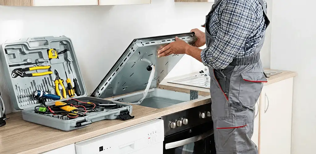 Handyman repairing a cooktop and checking wiring connections in Arlington, TX