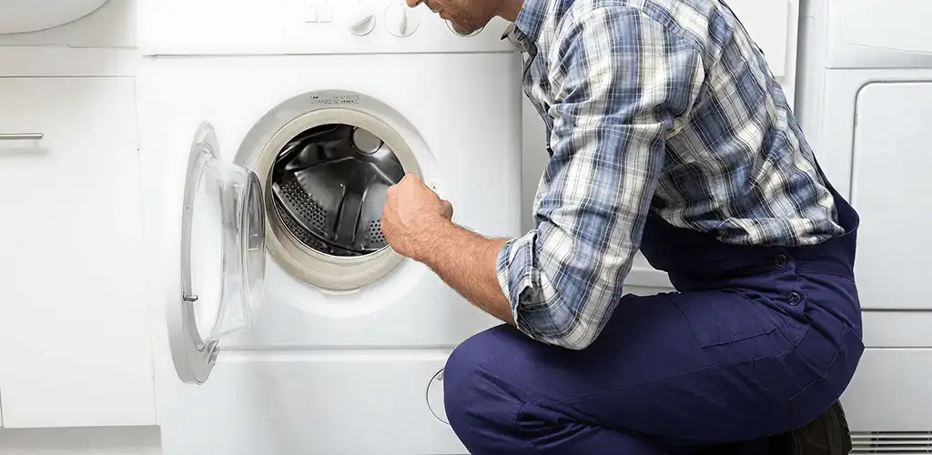 Handyman inspecting a dryer drum and internal parts for repair in Arlington, TX