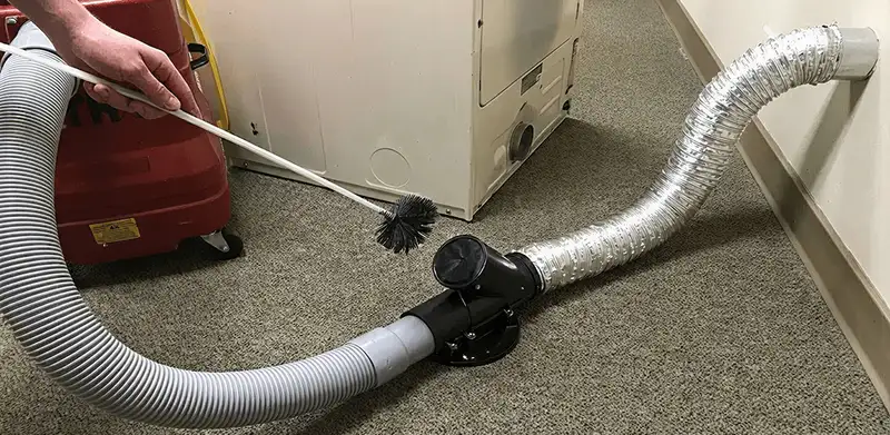 Dryer vent cleaning service removing lint from a dryer duct connection in Arlington, TX