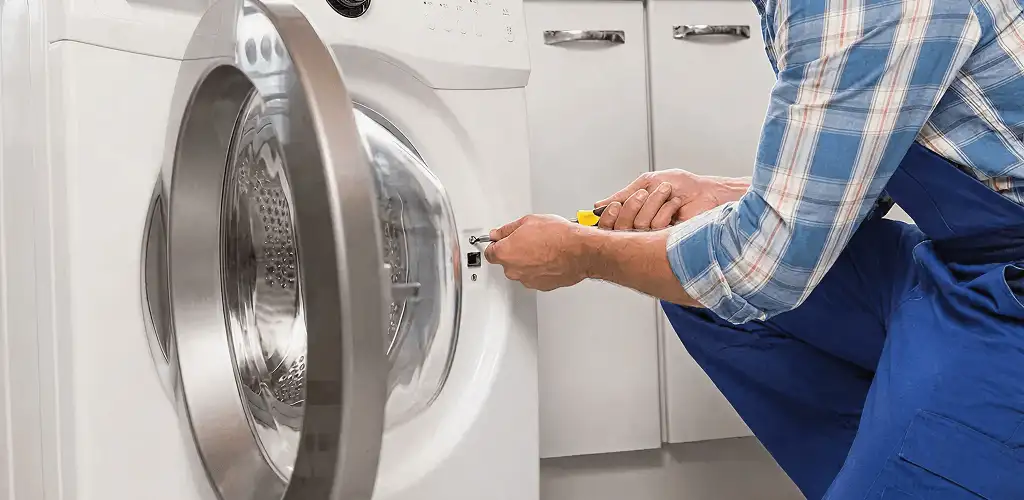 Handyman repairing a clothes dryer and checking electrical connections in Arlington, TX