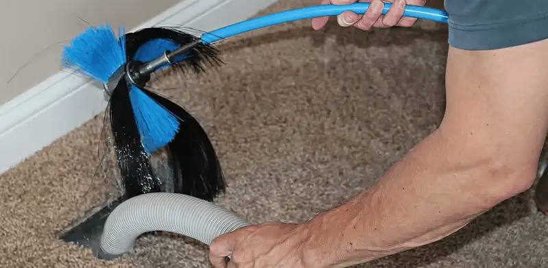 Dryer vent cleaning technician brushing lint from a vent line in Arlington, TX