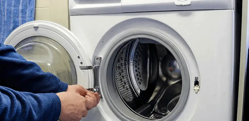 Washing machine repair handyman checking a front-load washer door and latch in Arlington, TX