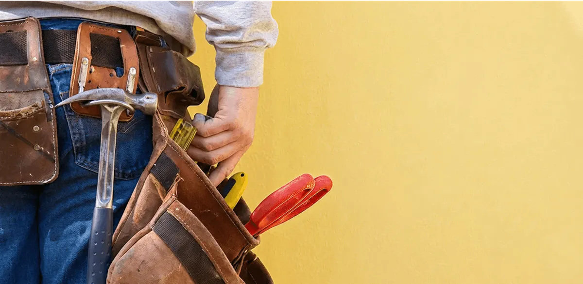 Handyman with tool belt ready for home repairs and maintenance in Arlington, TX