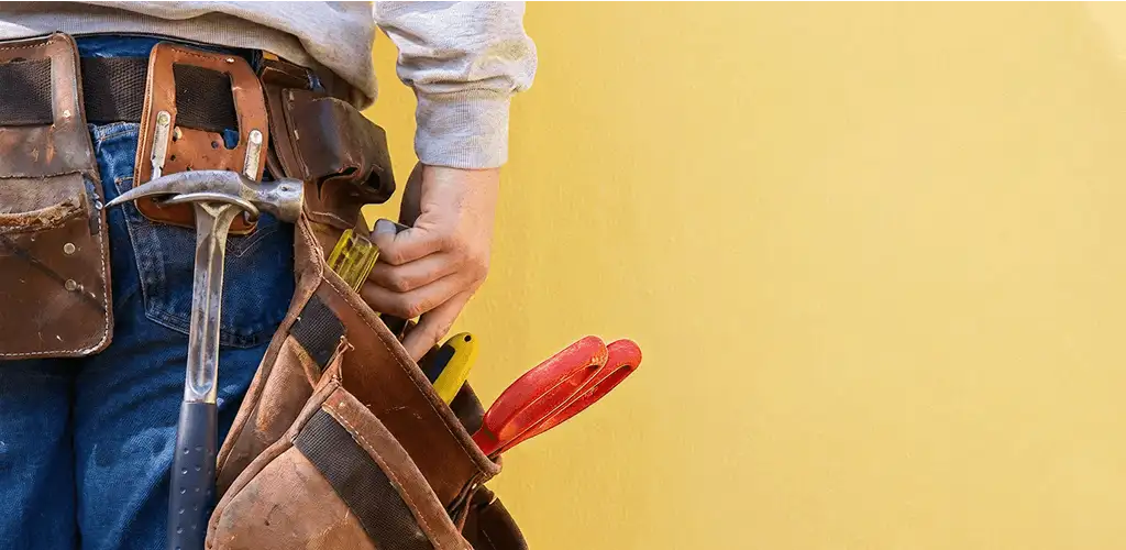 Handyman with tool belt ready for home repairs and maintenance in Arlington, TX