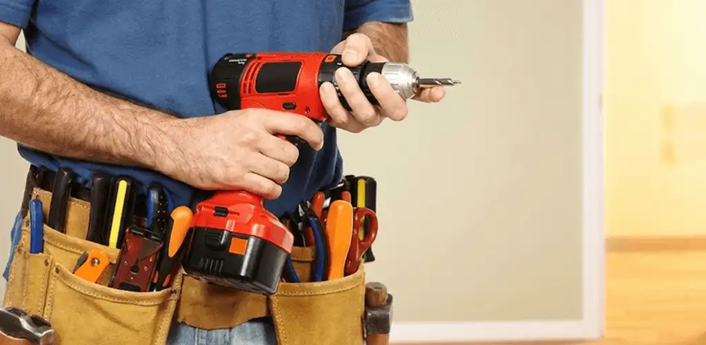 Handyman holding a power drill for home repairs and installations in Arlington, TX