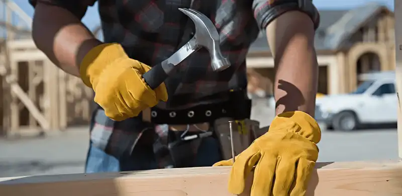 Handyman fixing wood trim with a hammer for home repairs in Arlington, TX