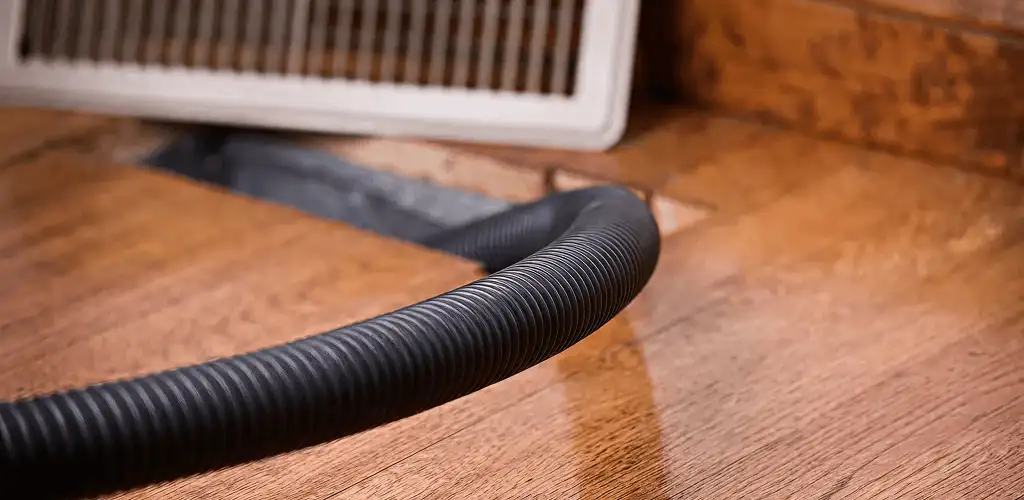 Air duct cleaning hose inserted into a floor vent for ductwork cleaning in Arlington, TX
