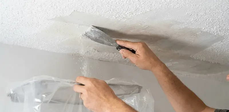 Popcorn ceiling removal technician scraping texture from a ceiling in Arlington, TX